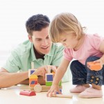 Father And Daughter Indoors Playing And Smiling